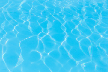  Niebieska woda w basenie z odbiciami słońca