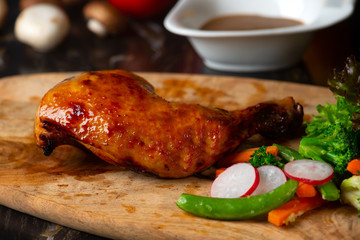 Wall Mural - Roast chicken on cutting board with raw ingredients