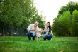 © MISHA - Happy family mother, father, child daughter. Happy young family spending time together outside in green nature. Happy family resting together on the green grass. Happy family having fun outdoors