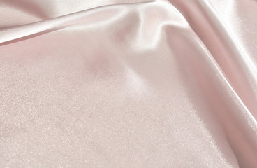 The texture of the satin fabric of beige color for the background 