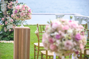 Wall Mural - Wedding ceremony. Arch, decorated with flowers on the lawn, beach background, sea in summer.