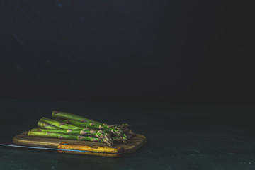 Wall Mural - Green asparagus on wooden cutting board