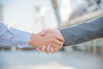 Wall Mural - Team Business Partners shaking hands together to Greeting Start up new project. Corporate Teamwork Partnership outside office modern city as background. Businessman with Hands together.