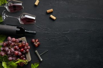 Wall Mural - Top view of tasty fruit plate with the wine bottle and glasses on the black stone on a kitchen plate on the black stone background, top view, copy space. Gourmet food and drink.