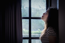 Broken Heart Young Woman Is Crying In A Dark Room With Rainy Season Background.
