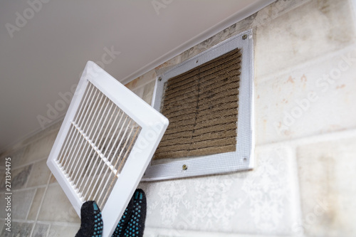 Cuadros en Lienzo repair service man removing a dirty air filter on a house so he can replace it with a new clean