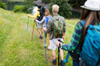 © NDABCREATIVITY - Group of happy friends with backpacks hiking together