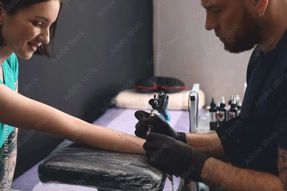 Professional artist making tattoo in salon