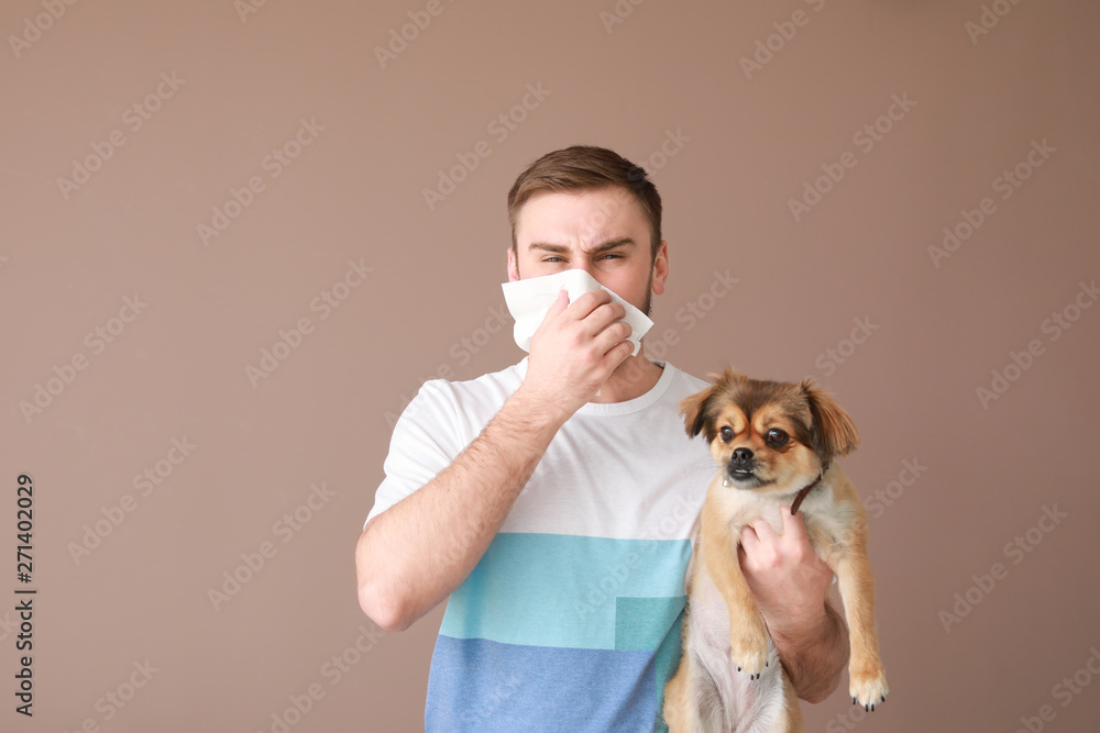 Man suffering from pet allergy on color background