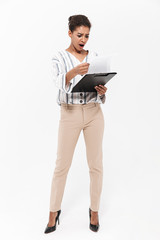 Wall Mural - Young beautiful african woman posing isolated over white wall background holding clipboard.