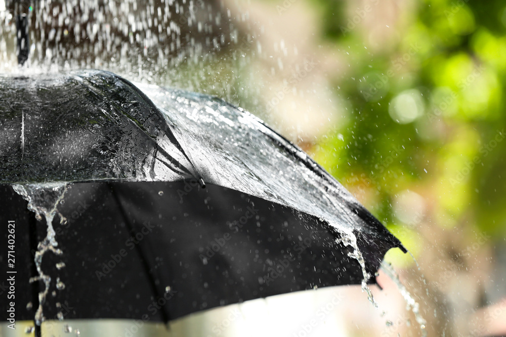 Black umbrella outdoors on rainy day
