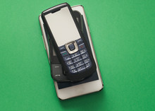 Old Retro Mobile Phones On Green Background