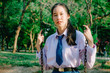 © TeTe Song - Portrait of asian girl student in school uniform Thailand style, sitting on swing and enjoy herself in windy and sunny day.