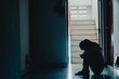 © TeTe Song - Silhouette of girl sitting alone in the dark,Sad and Serious women sitting hug his knee alone of old condo, Domestic violence, family problems, Stress, violence, with copy space