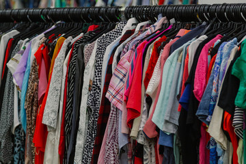 Beautiful colorful clothes in a store on hangers.