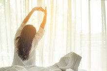 Asian Women Waking Up Stretching In Bed At Home, Morning And Sunny Day.  Lifestyle Concept