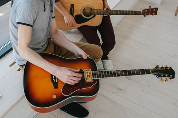 Wall Mural - Learning to play the guitar. Extracurricular activities or tutoring or hobbies or creative activities.