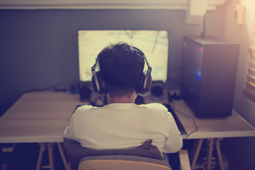 Portrait of asian boy gamer playing games on computer in the room at home.