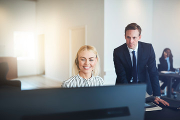 Wall Mural - Smiling businesspeople talking to clients on a headset at work