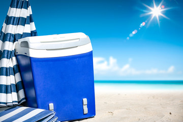 Wall Mural - beach fridge on sand with umbrella and free space for your decoration. Summer landscape of ocean and blue sky. 