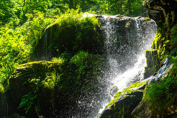 water spray from a waterfall as it launches itself off a cliff face