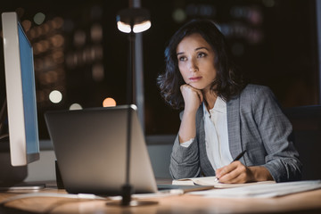 young businesswoman looking tired while working overtime in an office