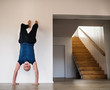 © Halfpoint - A senior man indoors at home, doing handstand exercise indoors.