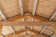 Background Of Wooden Vaulted Ceiling With Bearing Beams And Rafters Close Up