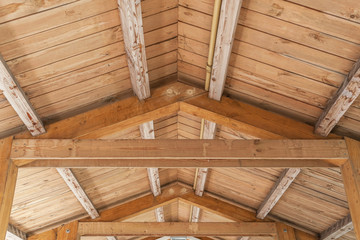 background of wooden vaulted ceiling with bearing beams and rafters close up