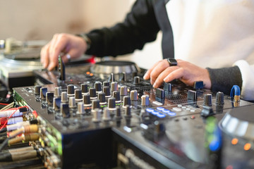 Wall Mural - Dj hands on a mixing console. Nightlife concept