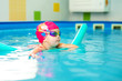 © Lena May - Cute baby girl in red swimsuit and special glasses playing in the pool