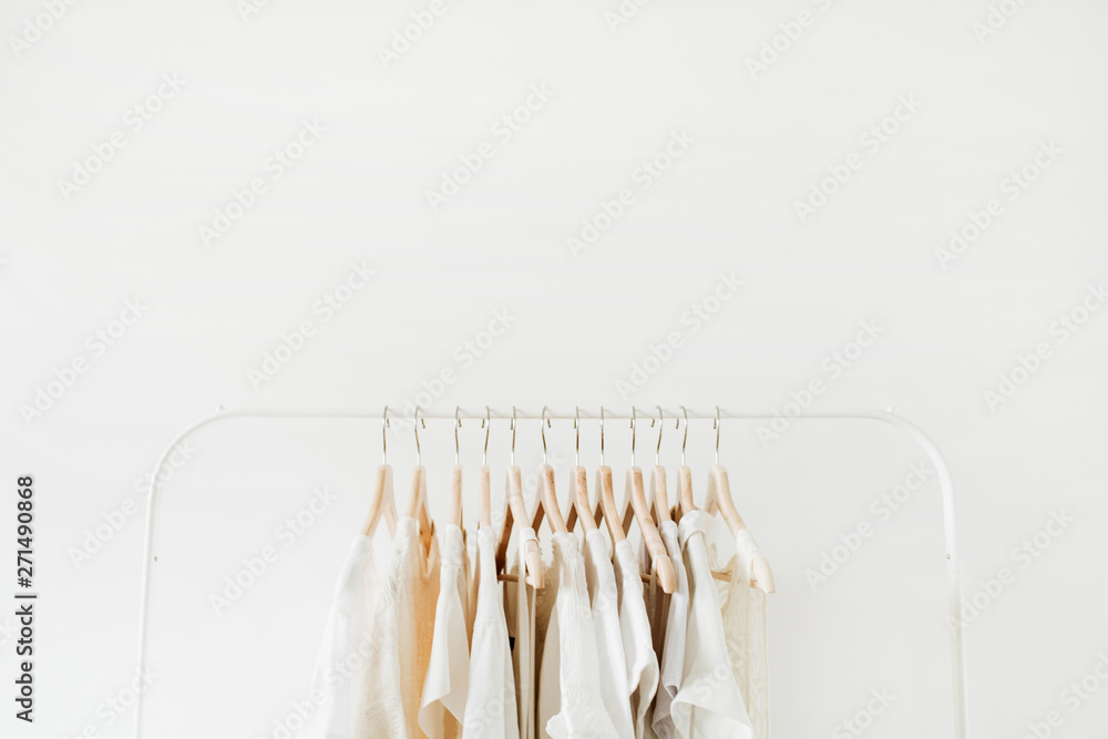 Minimal fashion clothes concept. Female blouses and t-shirts on hanger on white background. Fashion blog, website, social media hero header template. - obrazy, fototapety, plakaty 