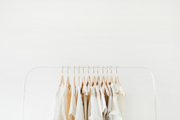 Wall Mural - Minimal fashion clothes concept. Female blouses and t-shirts on hanger on white background. Fashion blog, website, social media hero header template.