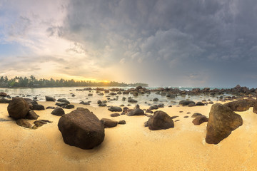 Wall Mural - tropical beach with rocks on sand coast of ocean