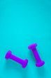 © Jaimie - Fitness equipment with womens purple weights/ dumbbells isolated on a light sky blue background with copyspace