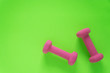 © Jaimie - Fitness equipment with womens pink weights/ dumbbells isolated on a lime green background with copyspace