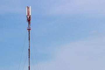 Telecommunication technology, tall mast with cellular telephone antenna aerial with copy space for text on blue sky background