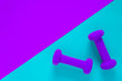 © Jaimie - Fitness equipment with womens purple weights/ dumbbells isolated on a light sky blue and purple background with copyspace