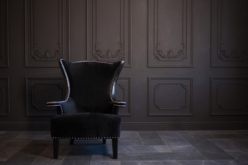 stylish black chair against a dark gray wall