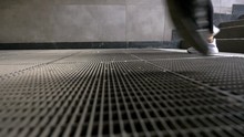 Pedestrian Feet And Legs Walking Across Metal Grating, Low Angle, Slow Motion