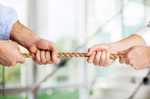 Fotografía Tug war, two businessman pulling a rope in opposite directions isolated on white