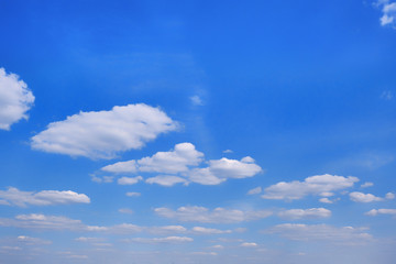 White clouds in clear spring weather. Sunny sky in the morning with floating clouds. Background of cloudy blue sky.