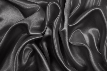 Black silk texture luxurious satin for abstract background. Dark tone of fabric