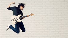 Portrait Of A Musician Jumping While Playing