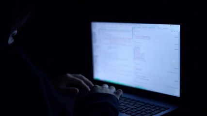 Hacker are hacking program on internet with laptop in dark room