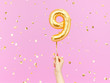 Nine year birthday. Female hand holding Number 9 foil balloon. Nine-year anniversary background. 3d rendering