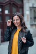 © bnenin - Portrait of a smiling female student in the city street.