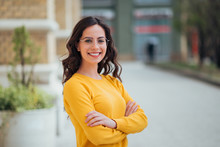 Portrait Of A Young Confident Woman Outdoors, Smiling At Camera.