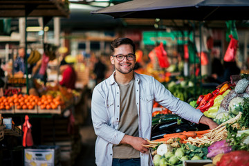 Handsome young man at farmer's market, looking at camera.