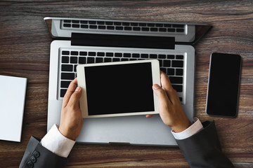 top view businessman or Designer using mobile phone with laptop and digital tablet laptop and document on desk in office network diagram in morning light